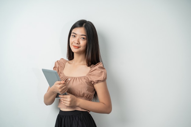 Beautiful woman with long hair seen from the side holding a tablet