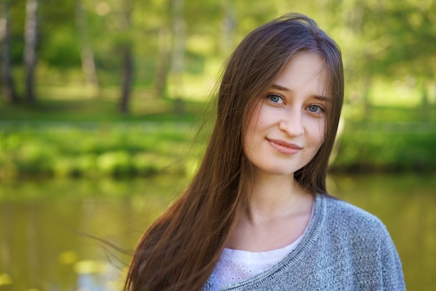 Beautiful woman with long hair standing next to the lake