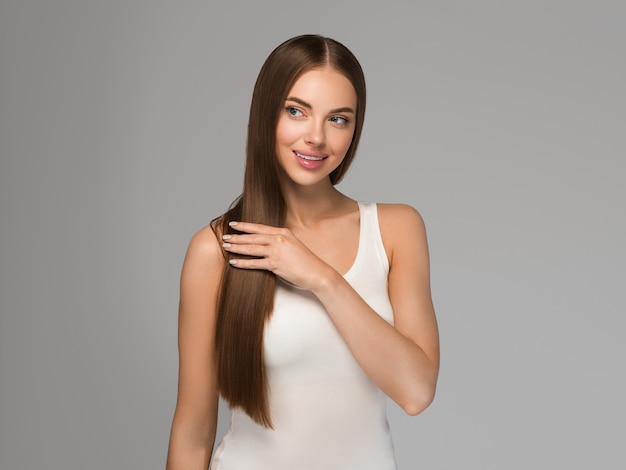 Beautiful woman with long healthy smooth hair beauty natural casual style. Color background gray