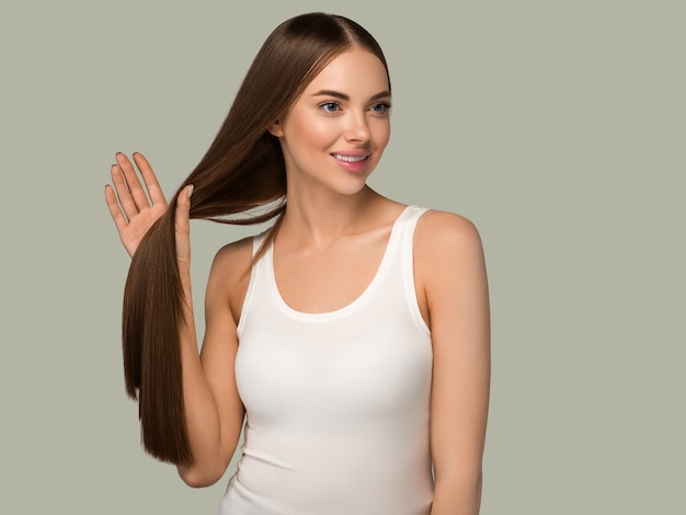 Beautiful woman with long healthy smooth hair beauty natural casual style. Color background green