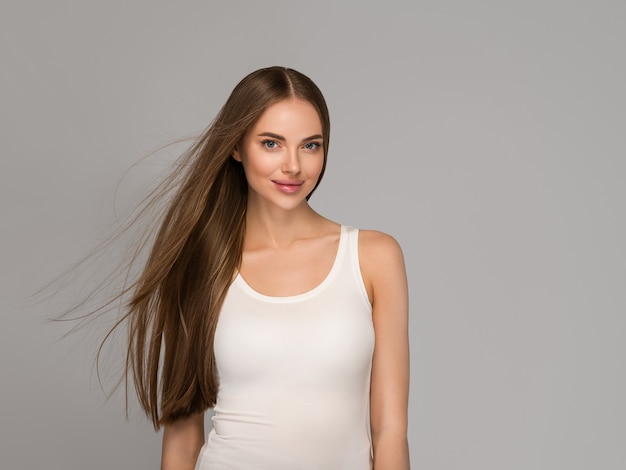 Beautiful woman with long  smooth flying hair tail beauty casual style. Color background gray