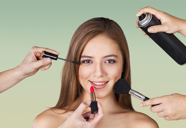 Beautiful woman with make up brushes on blurred background