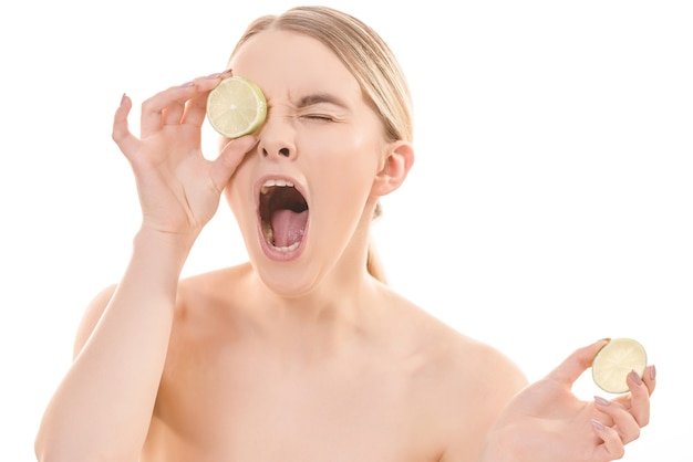 The beautiful woman with an open mouth and a lime on the white background