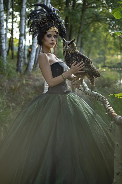 Beautiful woman with owl in the nature