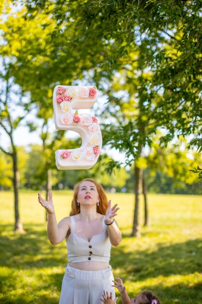 あなた自身の手で作られた手の装飾に花を持つ紙の番号を持つ美しい女性小さなb ...