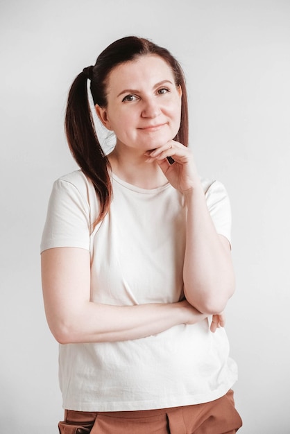 Beautiful woman with pigtails and a funny face wearing a Tshirt on a white background