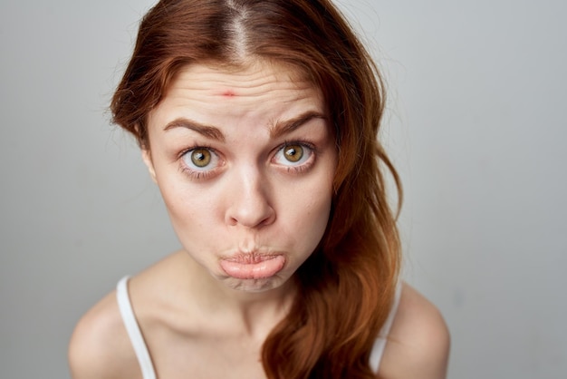Beautiful woman with a pimple on the face isolated\
background