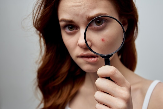 Beautiful woman with a pimple on the face isolated\
background