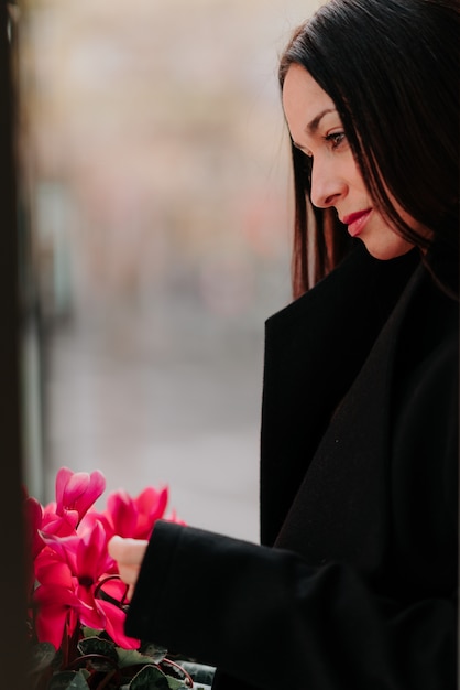 ピンクの花を持つ美しい女性