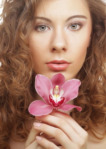 Foto bella donna con orchidea rosa