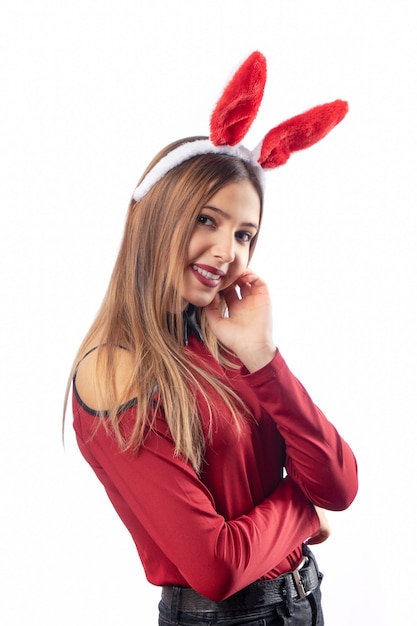 Beautiful woman with rabbit accessory posing on white.