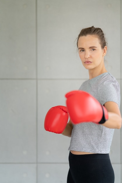 赤いボクシンググローブを持つ美しい女性