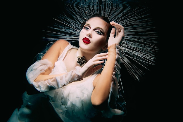 Photo beautiful woman with red lips and in women's jewellery underwater as the virgin mary