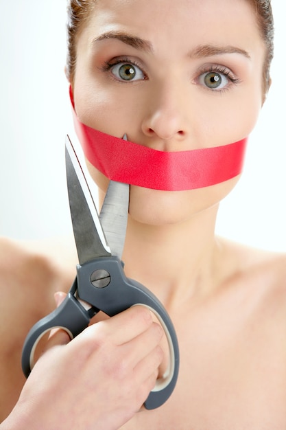 Beautiful woman with red tape on mouth portrait