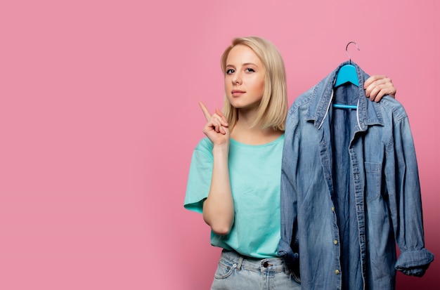 Photo beautiful woman with shirt on ahanger on pink wall