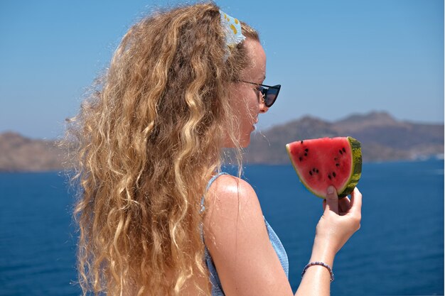 beautiful woman with a slice of watermelon wearing swimsuit