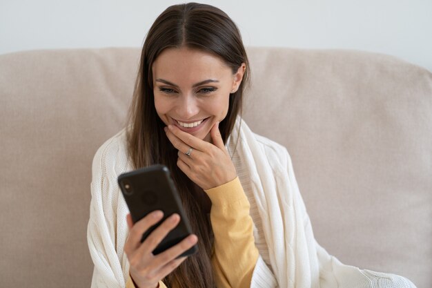 Beautiful woman with smartphone at home