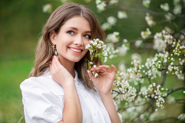 Beautiful woman with spring blooming flowers on a tree.
