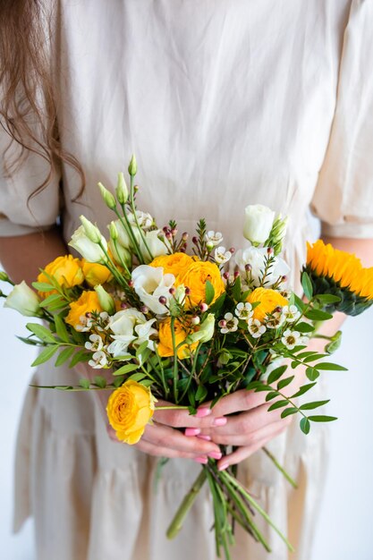 Beautiful woman with spring yellow bouquet of flowers spring and beauty concept