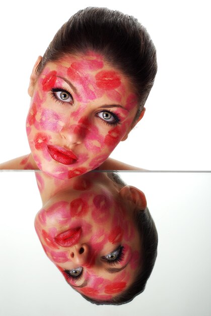 beautiful woman with stamps of red lipstick on her face