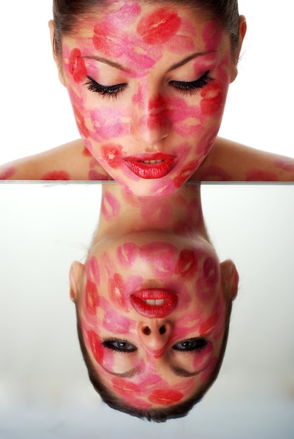 beautiful woman with stamps of red  lipstick on her face