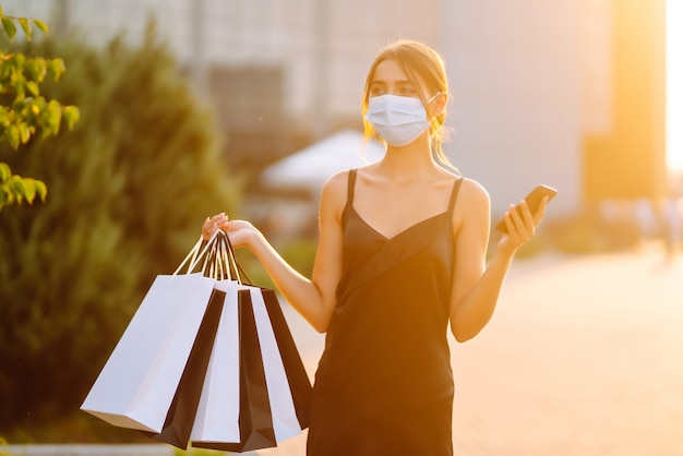 Beautiful woman with telephone enjoying shopping near shopping center.