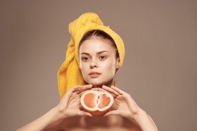 Beautiful woman with a towel on her head bared shoulders grapefruit Skin care