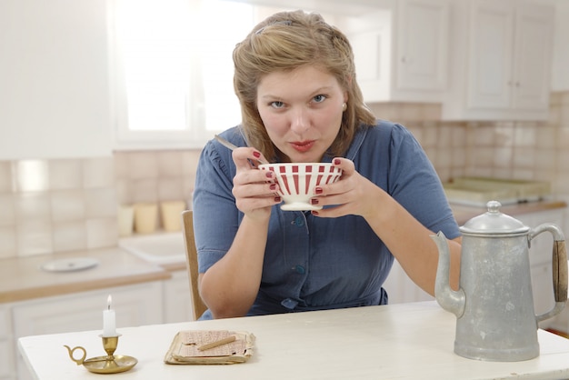 La bella donna con i vestiti d'annata beve un caffè