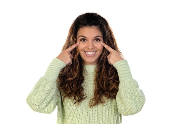 Beautiful woman with wavy hair wearing a green jersey isolated on a white wall