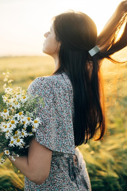 사진 꽃을 은 아름다운 여인, 빛에 보리에 서있는 꽃줄기, 저녁에 휴식을 취하는 스타일리시 여성, 여름 시골에서 꽃을 모으는 분위기, 조용한 순간