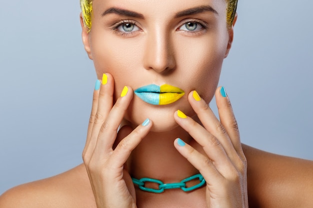 Foto bella donna con i capelli gialli e unghie e labbra colorate