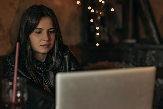 Beautiful woman working on laptop in bar