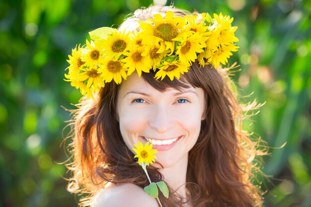 Beautiful woman in wreath of spring sunflower