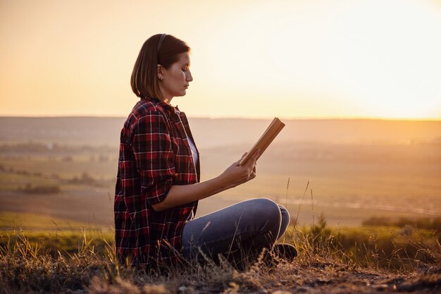 Beautiful woman writing into her diary in the park