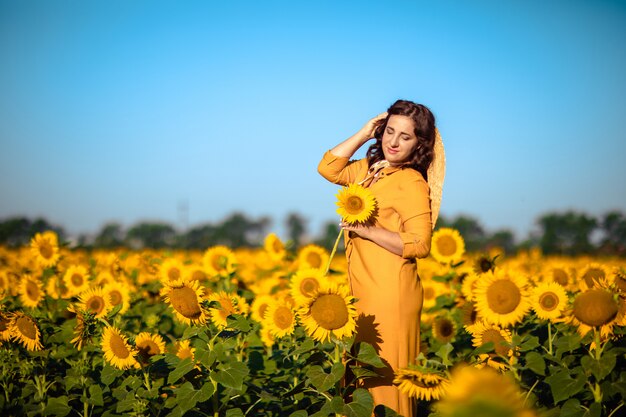 해바라기 밭에 노란 드레스에서 아름 다운 여자
