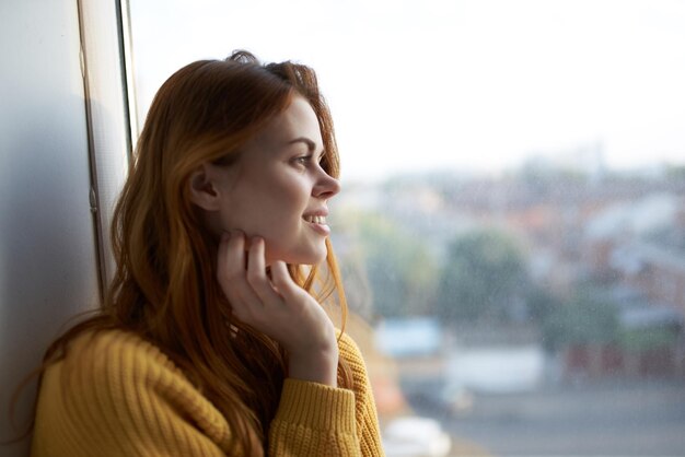 Beautiful woman in a yellow sweater at home