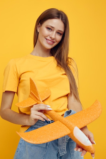 Beautiful woman in yellow tshirts pink feathers isolated background