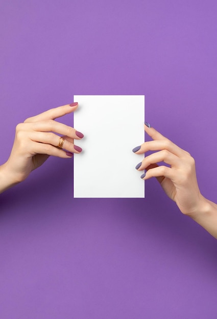 Beautiful womans hand with manicure holding postcard