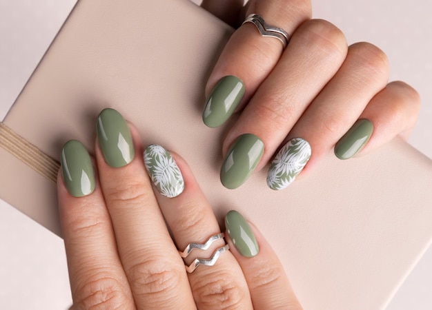 Красивые женские руки с весенним летом цветочным дизайном ногтей