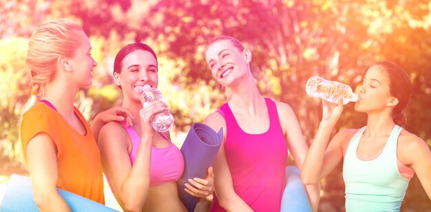 Beautiful women holding exercise mat in park