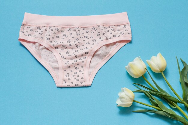 Photo beautiful women's cotton panties on a blue background