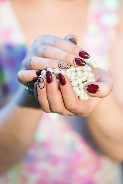 真珠を保持している美しい女性の手