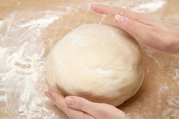 Beautiful women's hands knead the dough for baking