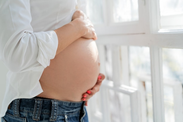 Beautiful Women's Hands Support The Belly Of A Pregnant Woman