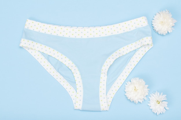 Beautiful women's panties with flowers on blue background.