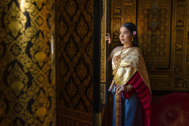 Beautiful women Thai girl holding hand lotus in traditional thai costume.