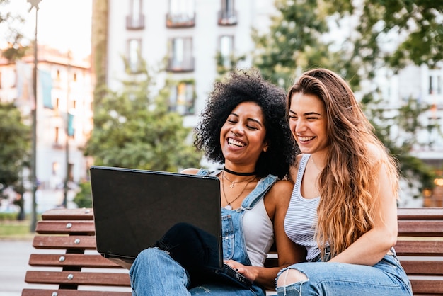 Beautiful women using a laptop in the Street. Youth concept.