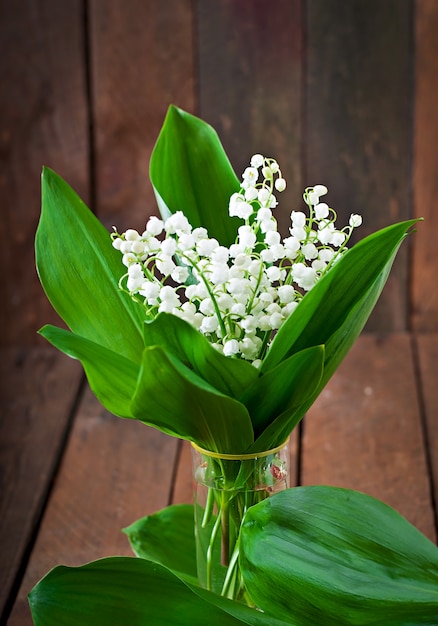 Beautiful wood lilies of the valley on a wooden table