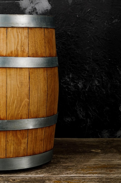 A beautiful wooden barrel and a worn oak wood table set against a dark wall pattern for the design