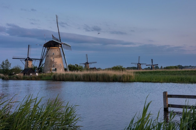 Beautiful wooden windmills at sunset in the dutch village of kinderdijk windmills run on the wind